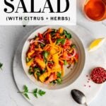 pinterest pin featuring Bell Pepper Salad on an earthenware plate next to a lemon wedge and pinch bowl filled with pink peppercorns