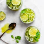 three glasses of herbal limeade on garnished with lime, mint and cilantro