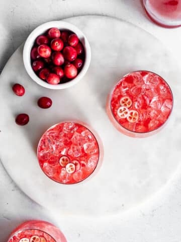 Cranberry kvass served with ice, garnished with sliced cranberries