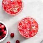 Cranberry kvass served with ice, garnished with sliced cranberries