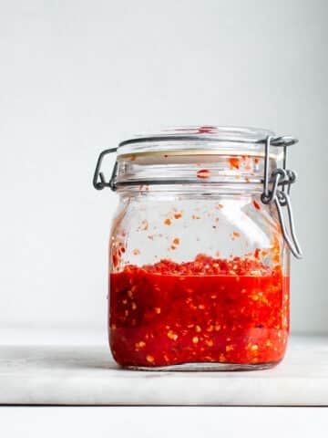 Fermented pepper mash in a glass jar with a clamp lid.