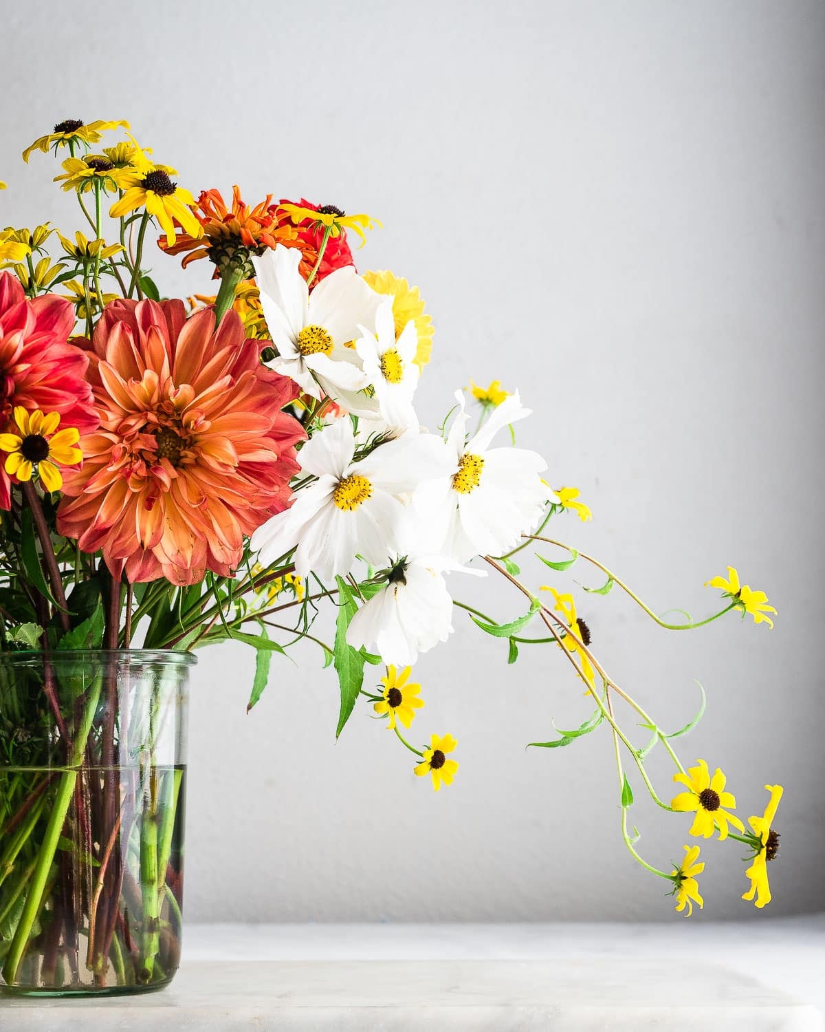 Decorative flowers in vase on white surface