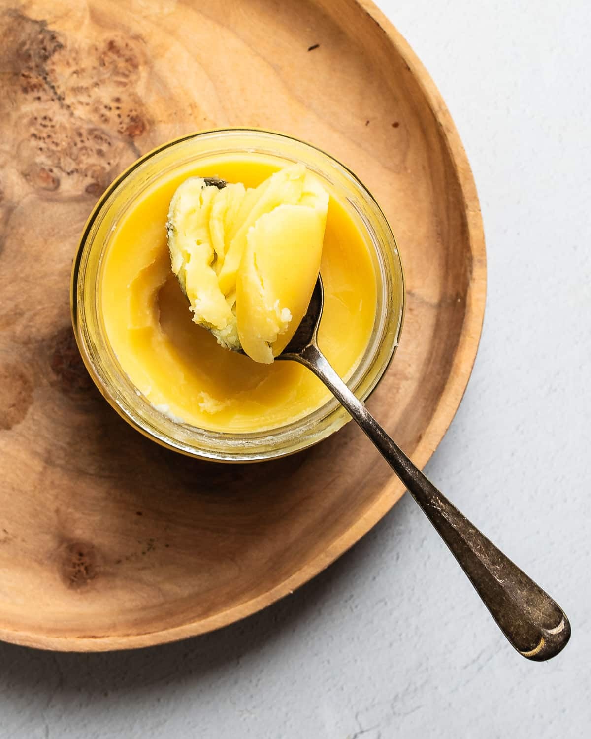 ghee in a jar on a wooden plate