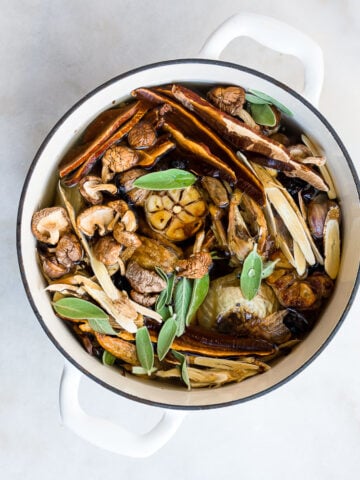 medicinal mushroom broth in a pot with a sage leaf