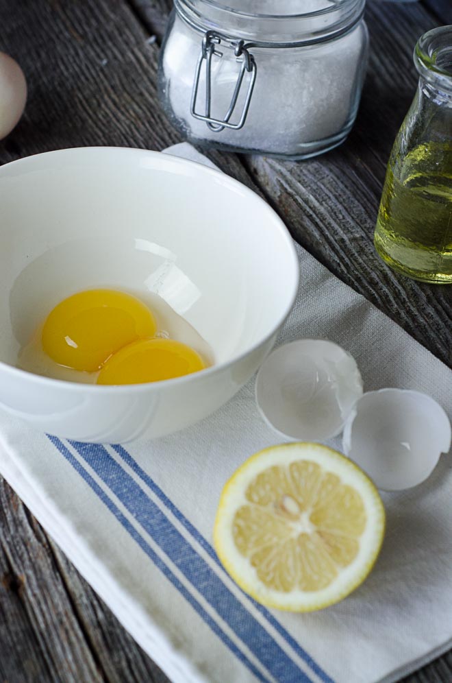 egg yolks in bowl next to sliced lemon