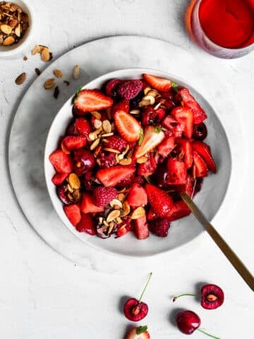 Red fruit salad with strawberries, raspberries, cherries and watermelon in a white bowl