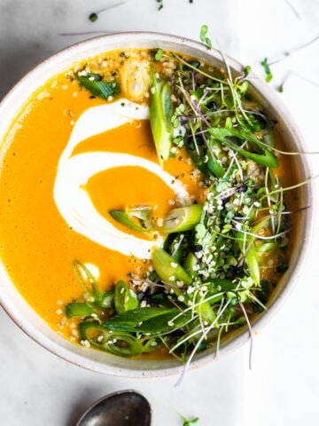 red kuri squash soup garnished with herbs