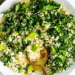 risotto with spring vegetables and herbs on a white background