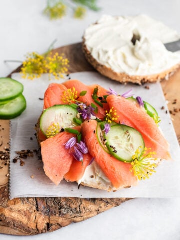 salmon lox on a plate with a bagel and cream cheese on the side
