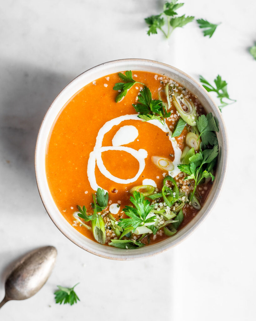 Tomato and white bean soup garnished with parsley, green onions, and sour cream.